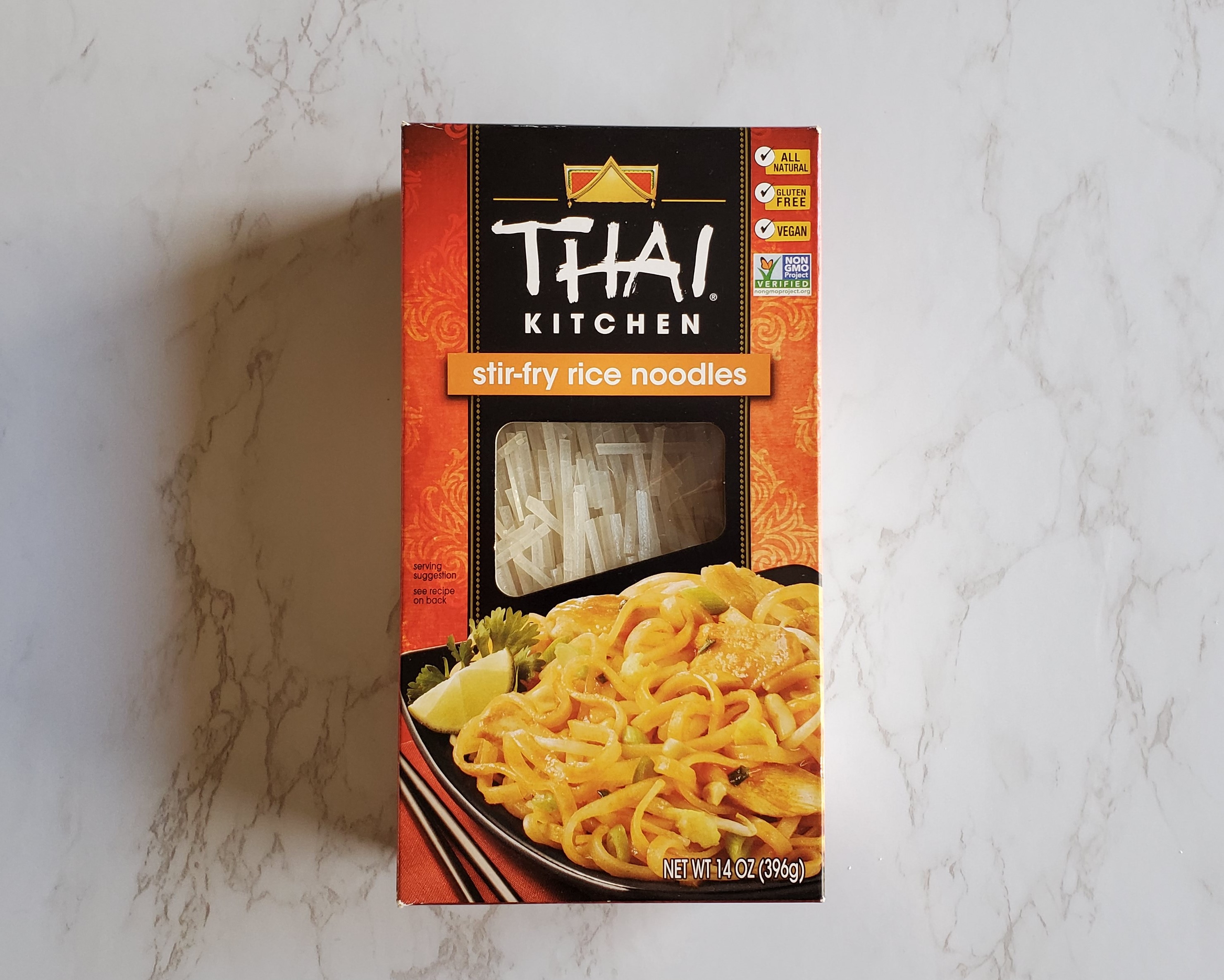 A box of Thai Kitchen stir-fry rice noodles on a white marble background.
