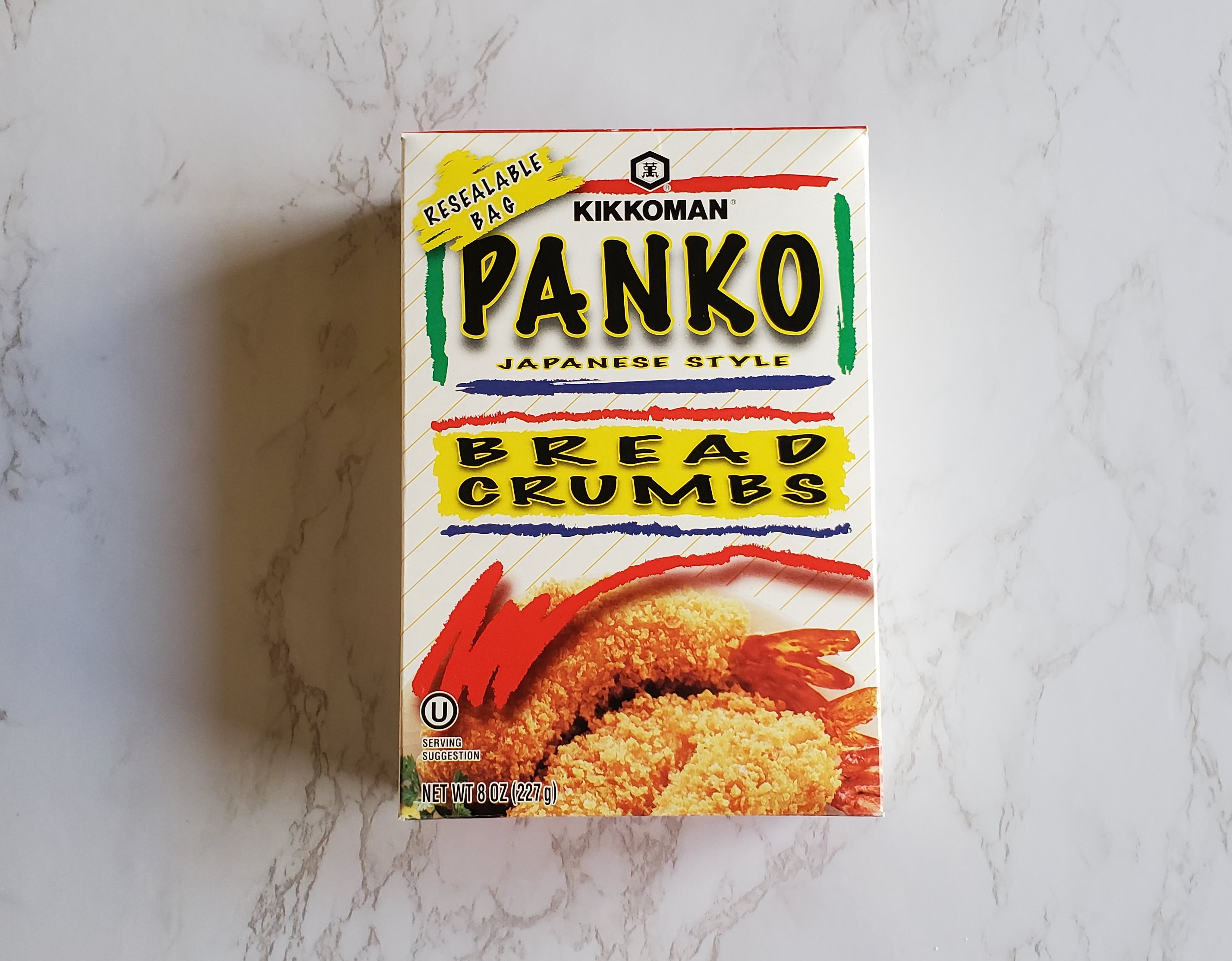 A box of Panko Kikkoman Japanese style bread crumbs on a white marble background.