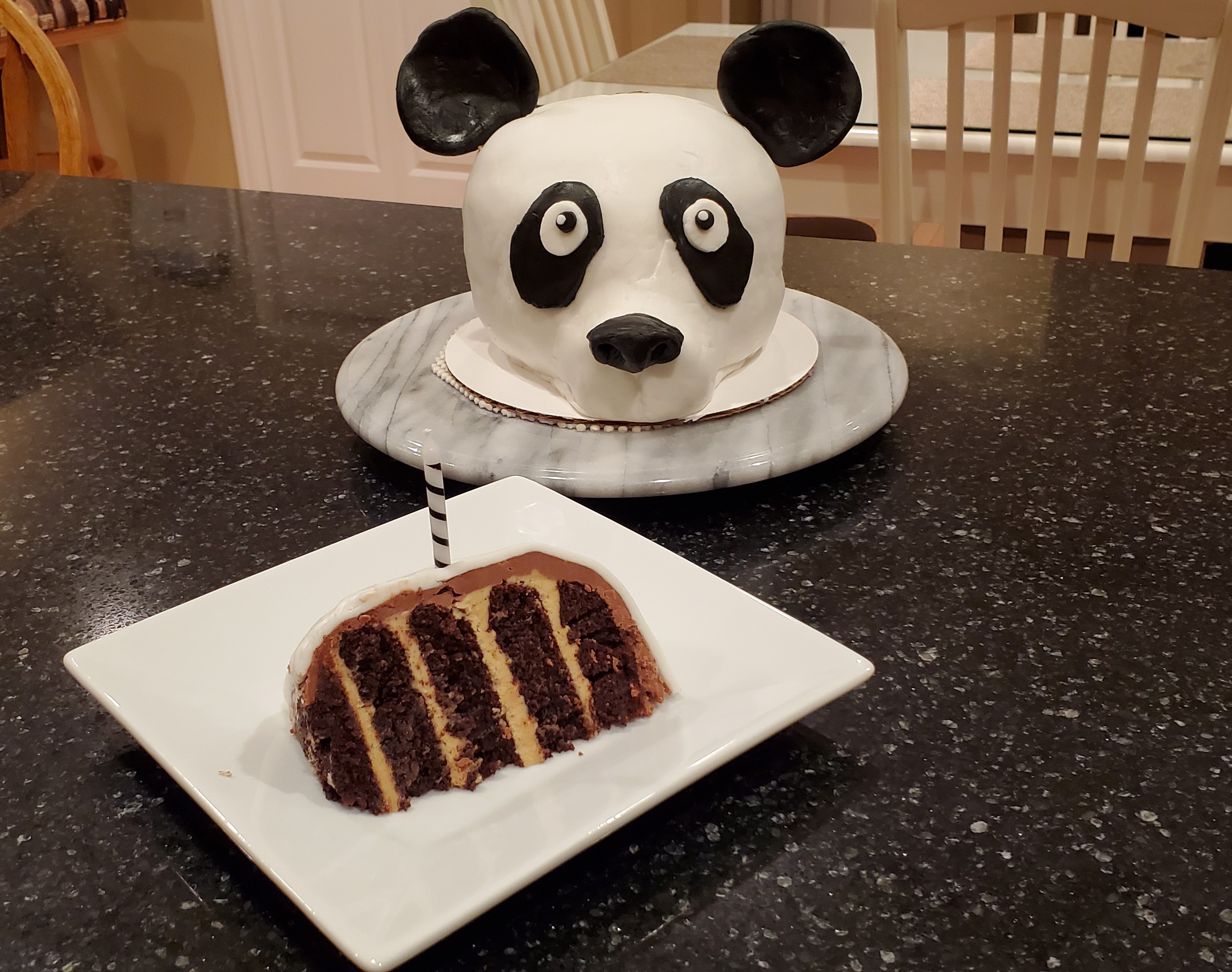 A 5 layer slice of panda chocolate cake with peanut butter and chocolate frosting.